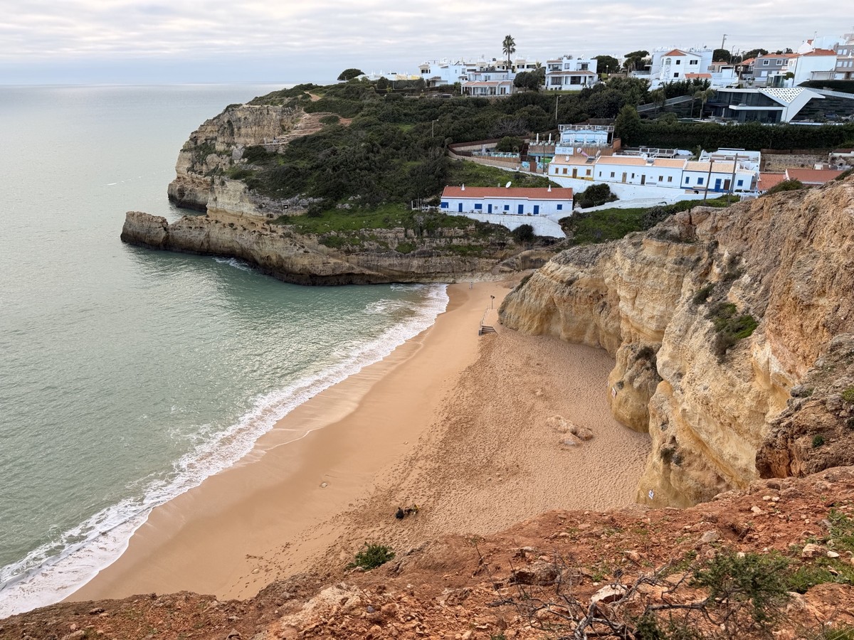 A sandy rock tunnel leading towards an Algarve beach